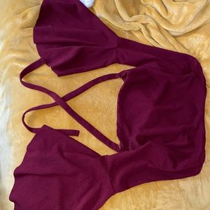 A burgundy crop top that crosses in the back
